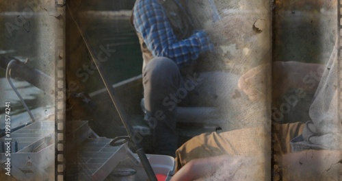 Fishing two men wearing blue plaid, grey top in small boat, handling tackle box, filmstrip borders