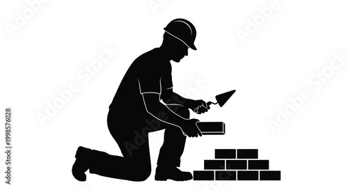 Construction worker kneeling and applying mortar a striking silhouette
