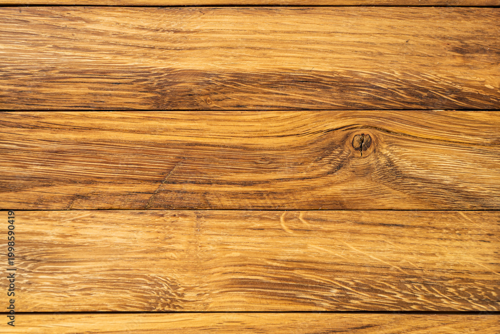 Fototapeta premium Close-up view of natural wooden planks with rich grain texture. The warm tones and intricate details make it suitable for interior design, backgrounds, and creative projects.