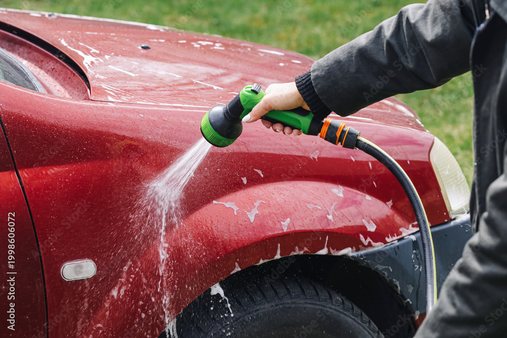 Φωτογραφία Washing red car with garden hose