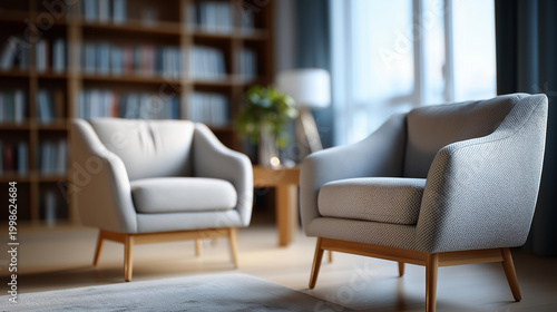 Cinematic wide shot of a minimalist therapy office with two empty armchairs facing each other on a soft bright neutral rug softly defocused bookshelf behind therapy room