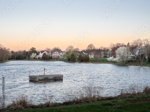 Ashburn Village lake with spillway at sunset in Virginia