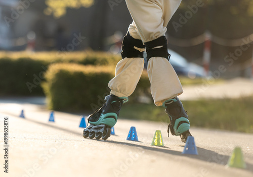 Obraz na płótnie Teen Practices Skate Tricks On Rollerblades With Training Cones Close-Up Feet