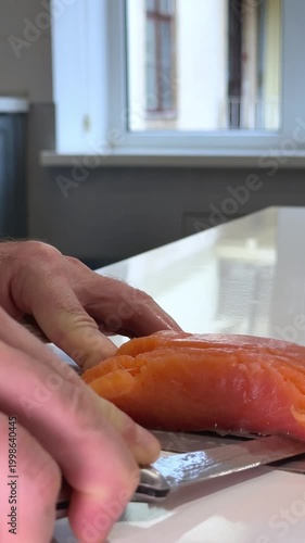 Male hands slicing salmon on white plate lemon tomato avocado healthy food preparation closeup