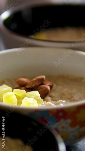 Oatmeal bowls with nuts dried fruits pineapple closeup healthy breakfast variety plates