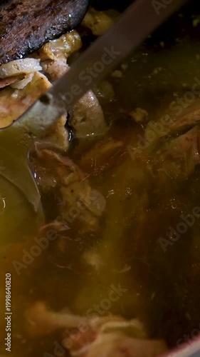 Vietnamese pho bo soup with various herbs, cinnamon, cinnamon stick, star anise, and onion. Cooking pot with bone broth meat pork and beef, aspic north food. spices on kitchen table. 