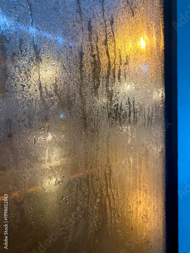 А foggy window in the rain and city lights weather season vertical photo background wallpaper vertical orientation 