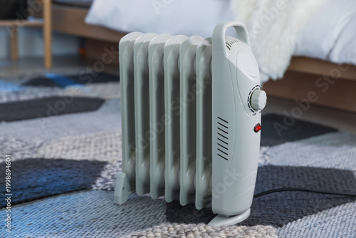 Fotografija Modern portable electric heater on floor in bedroom