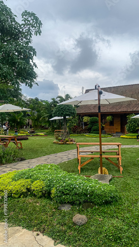 Garden outdoor cafe with tables, umbrellas, and greenery in relaxing setting