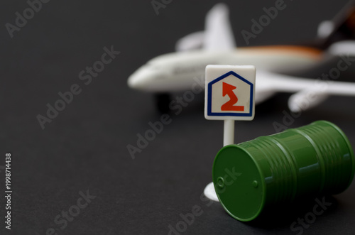 Tourism and Energy Crisis: Miniature Airplane and Oil Drums Illustrating Flight Costs