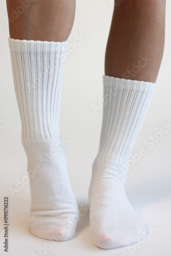 Female Legs Wearing White Ribbed Crew Socks Front View Minimal Studio Shot