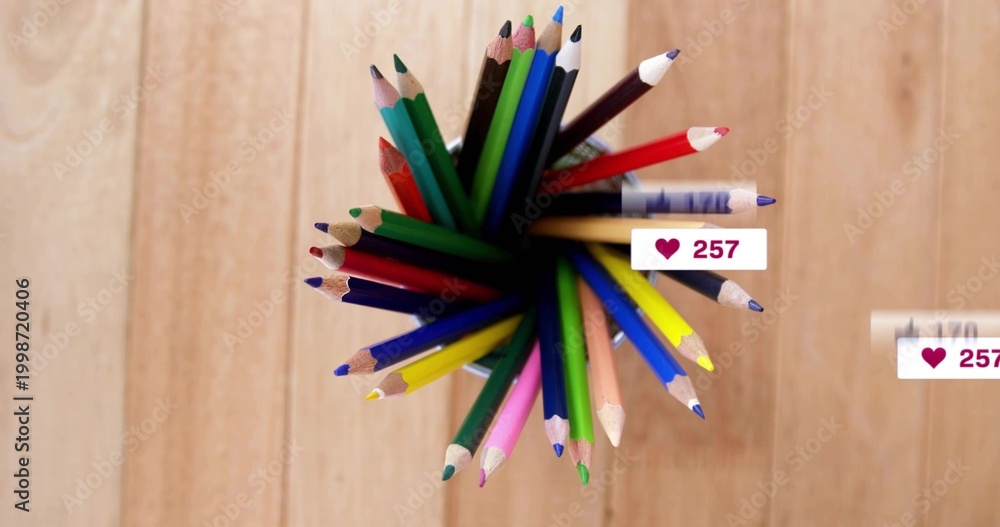 Fototapeta premium Showing dark holder holding sharp colored pencils fanning on light wood table with heart badges 257