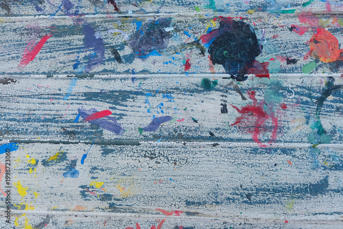 A wooden panel stained with various art prints.