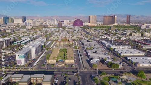Aerial pullback shot of Las Vegas suburbs and Strip skyline and mountains 