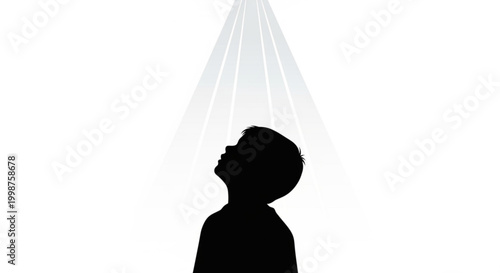 Silhouette of a young boy looking up at a bright light source