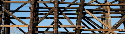 Fotografie Galvanized iron pole splint, reinforcing metal with collar clamps on old wooden