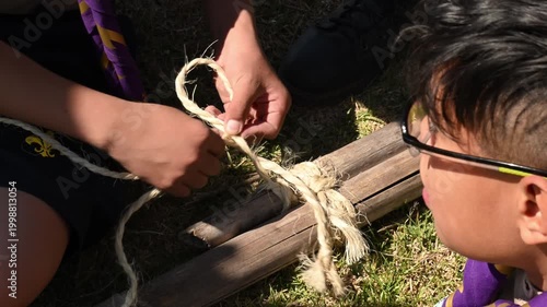 young scouts tying knots in sticks