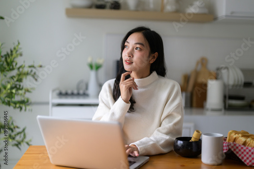 Konstfotografi Young Asian woman contemplating new ideas at home