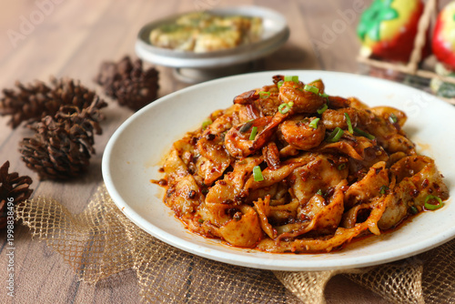 Tableau sur toile It's a plate of chili oil noodles made with broad noodles tossed in aromatic chili oil and flavorful spicy sauce, then topped with sautéed shrimp