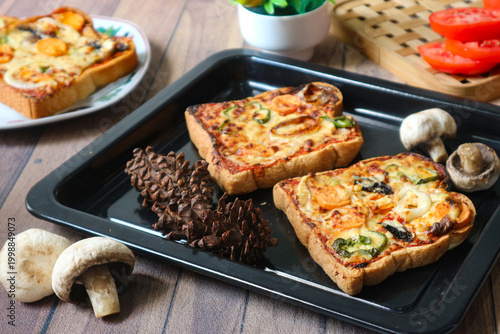 Canvastavla It's a plate of pizza toast made of bread, melted cheese, bell pepper, and mushroom