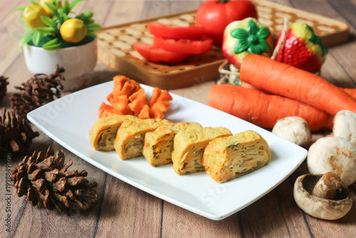 Foto It's a plate of rolled omelet with diced vegetables, also called gyeran-mari in