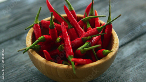 Tableau sur toile closeup shot of small wooden bowl filled with pile of fresh and ripe red spicy c