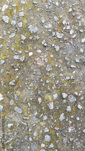Close-up view of rough asphalt road surface with small stones and gravel texture. Concrete pavement of the pedestrian road