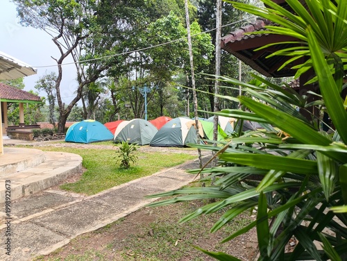 Fotografía A serene campsite nestled among trees with colorful tents
