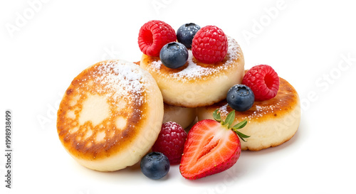 Delicious sweet Russian syrniki cottage cheese pancakes with fresh berries, beautifully isolated on a clean white background