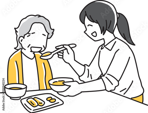 高齢者の食事を手伝う介護士