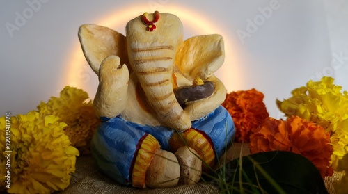 Lord Ganesha idol with marigold flowers and soft halo lighting festive setup