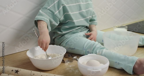 Little girl mixes ingredients at kitchen counter