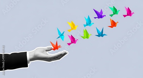 hand releasing colorful origami birds into the air
