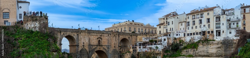 Obraz premium Puente Nuevo dramatic bridge spanning a deep limestone gorge creating iconic architectural landmark in Ronda, Spain.