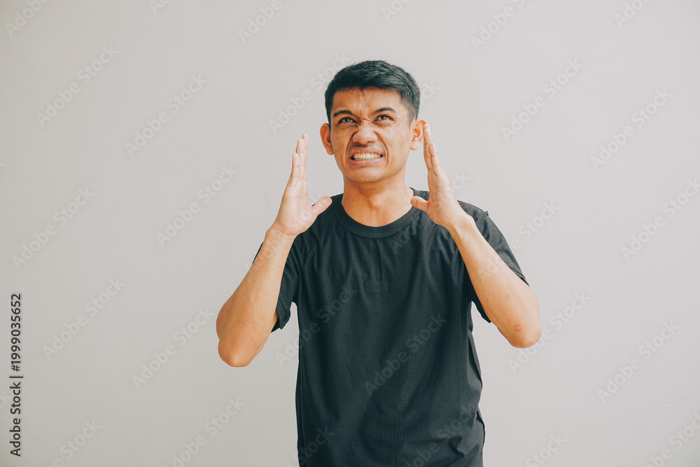 Fototapeta premium man showing frustration with hands up against plain background, studio lighting