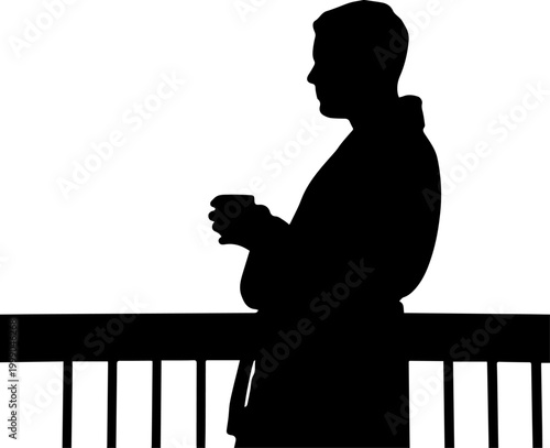 Black silhouette of a man wearing a bathrobe and holding a cup of coffee while standing on a balcony railing