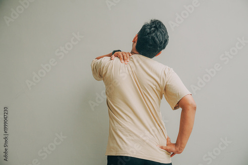 man with back pain isolated on gray background