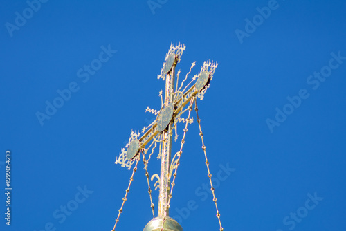 Ornate Golden Orthodox Cross Against Clear Blue Sky