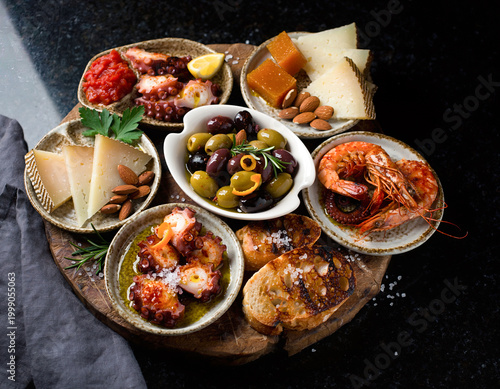 45-degree angle view of Spanish tapas variety presented in a vibrant flat lay arrangement.