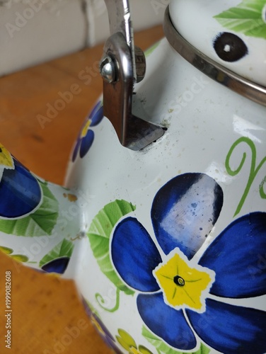 Enamel painted kettle, close-up of enamel chips on lid and surface