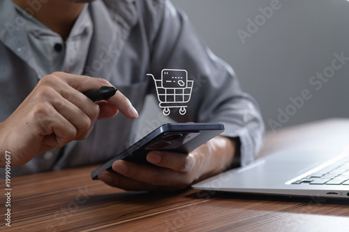 Quadro su tela Man Using Smartphone for Online Shopping with Laptop on Desk
