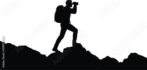 Silhouette of hiker with backpack using binoculars on a mountain