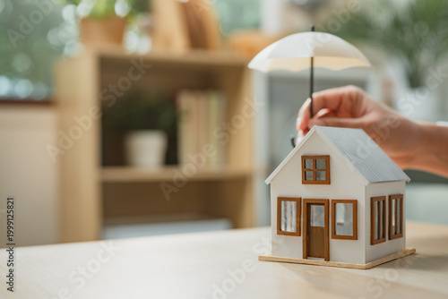 Quadro su tela Home insurance concept with house model protected by umbrella symbolizing risk coverage, property protection, and financial security, representing homeowner safety, insurance policy planning