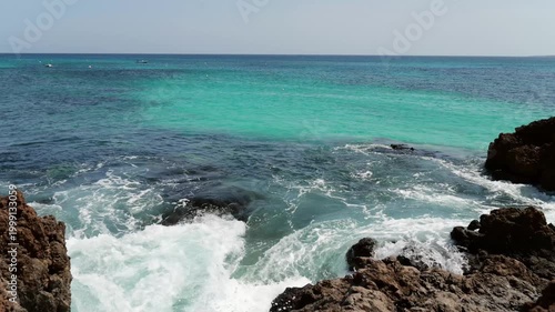 View from promenade in Punta Mujeres over turquoise sea and lava coastline in Lanzarote. Suitable for travel, relaxation and island atmosphere.
