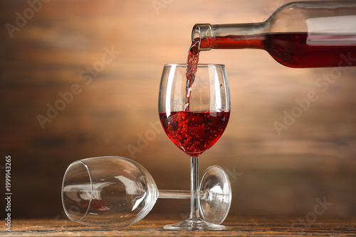 Pouring of red wine into gl...