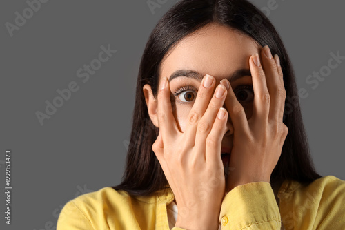 Scared young woman on dark ...