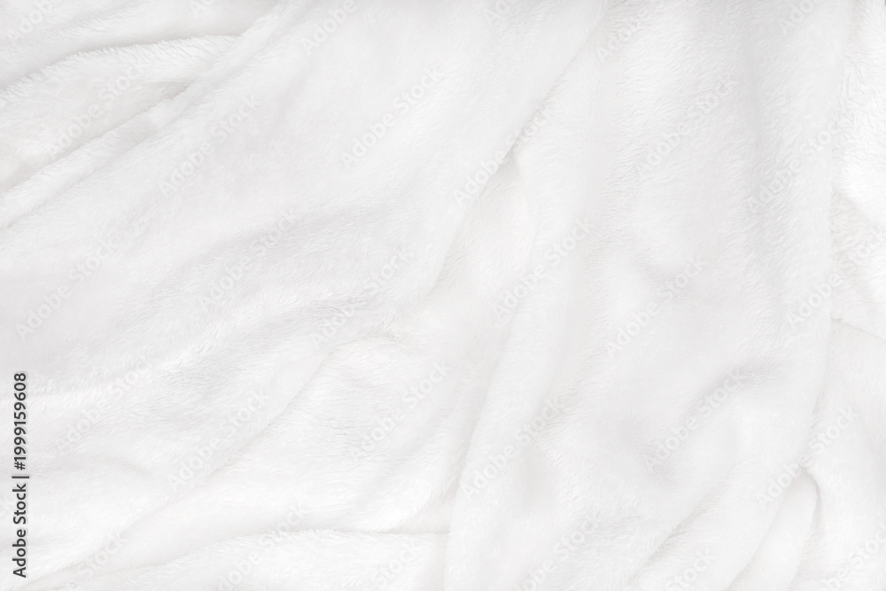 Fototapeta premium soft white blanket is spread out on a flat surface, its soft texture visible through it. It lies comfortably and feels warm.