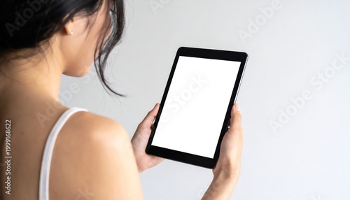 Woman holding tablet with blank screen for mockup template.