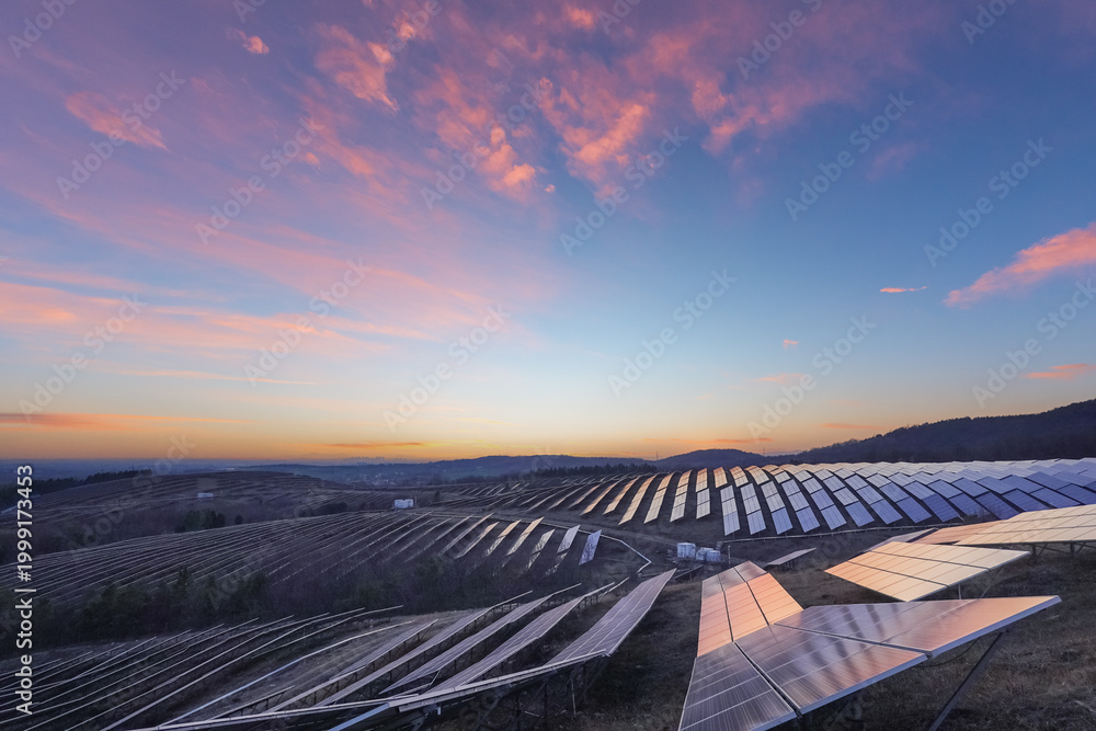 Fototapeta premium Solar Power Plant on Hillside Under Colorful Morning Sky