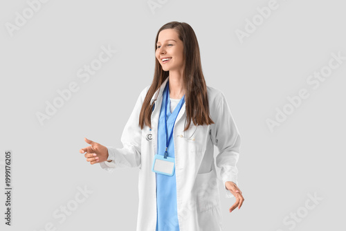Female medical intern on light background